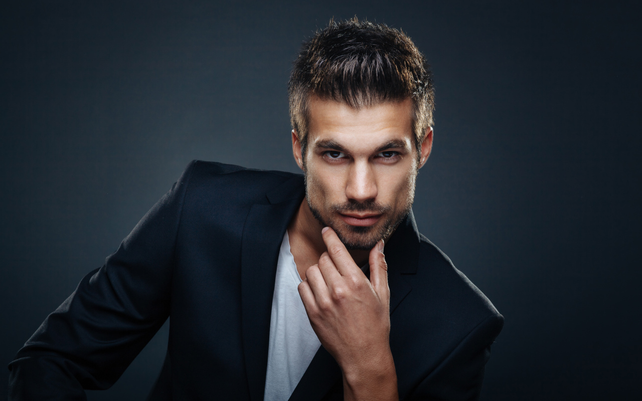 Красивый стильный мужчина в костюме на сером фоне