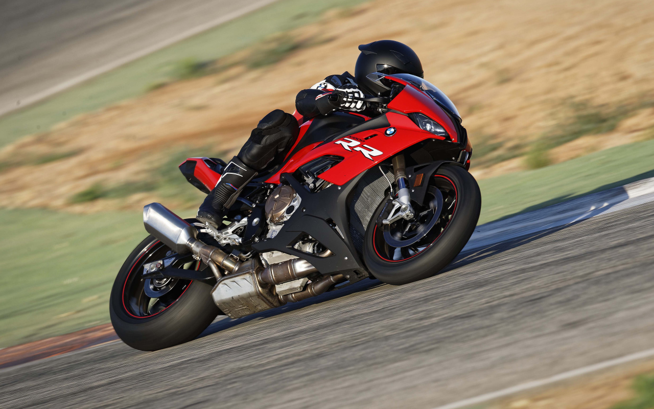 Гонщик на мотоцикле BMW S1000 совершает крутой поворот