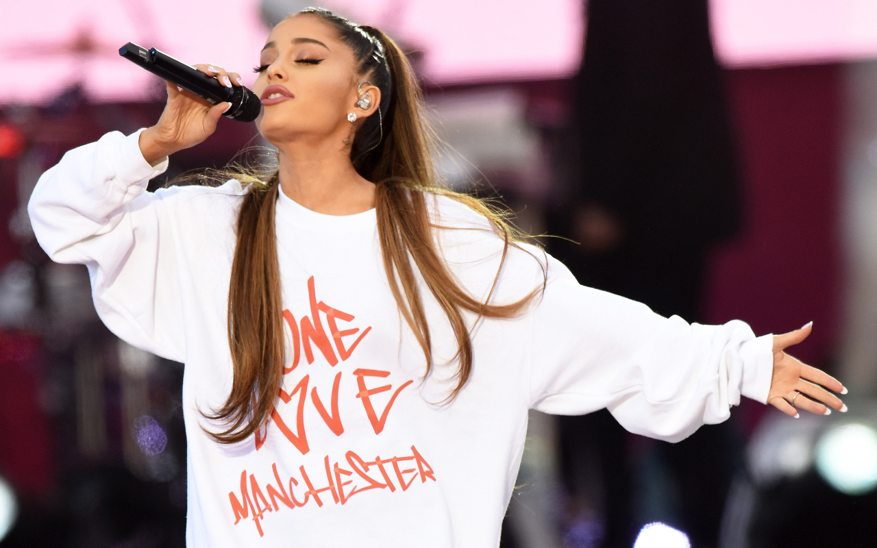 Молодая девушка, певица Ариана Гранде поет на сцене