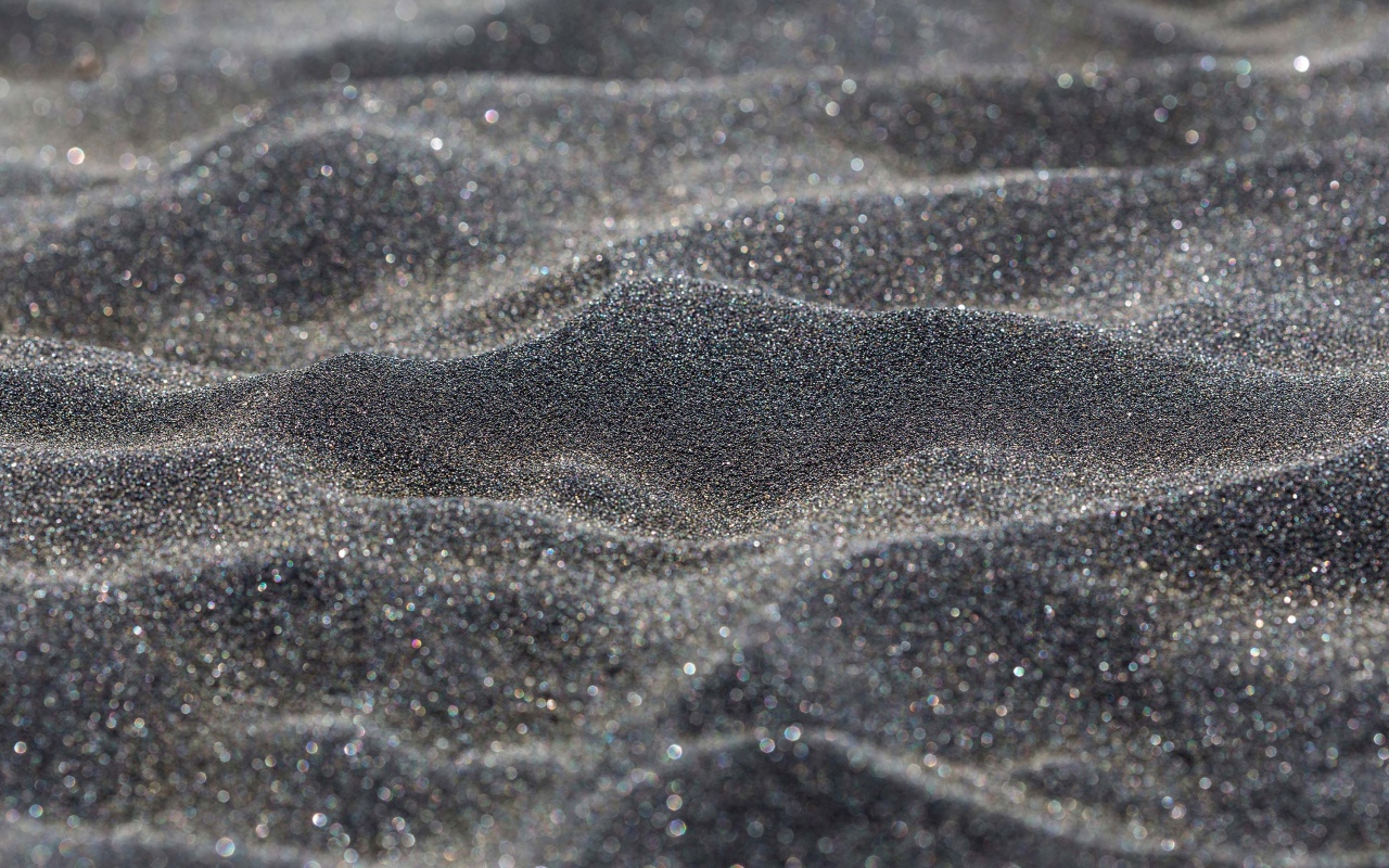 Блестящий черный песок крупным планом