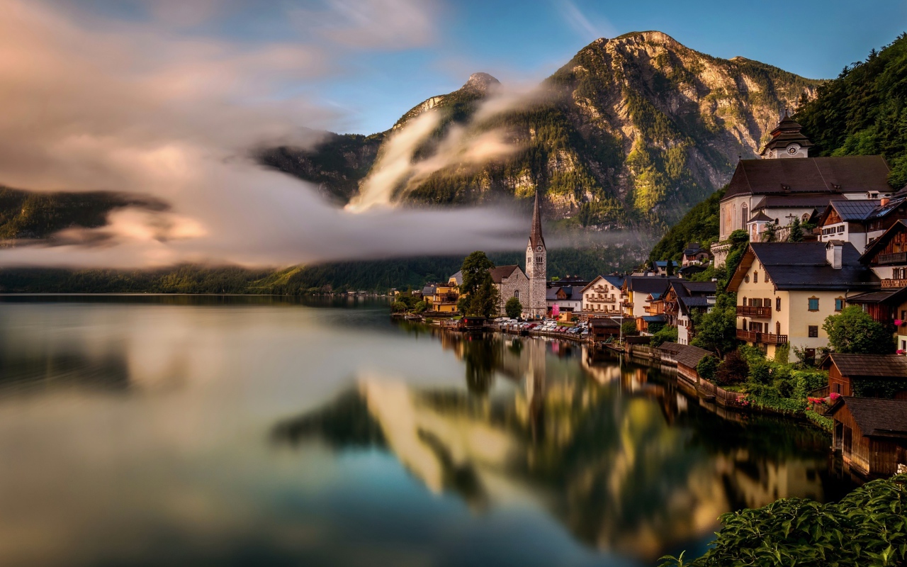 Город Гальштат над туманным озером в горах Альпы, Австрия
