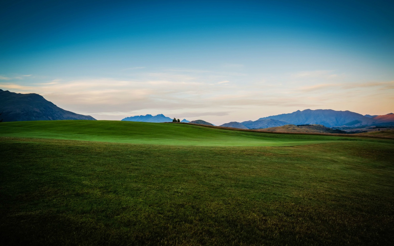 Зеленый луг на фоне красивого неба