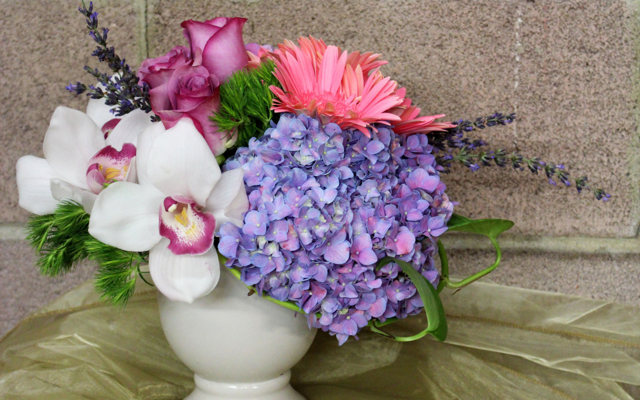 Красивый букет в белой вазе на фоне стены 