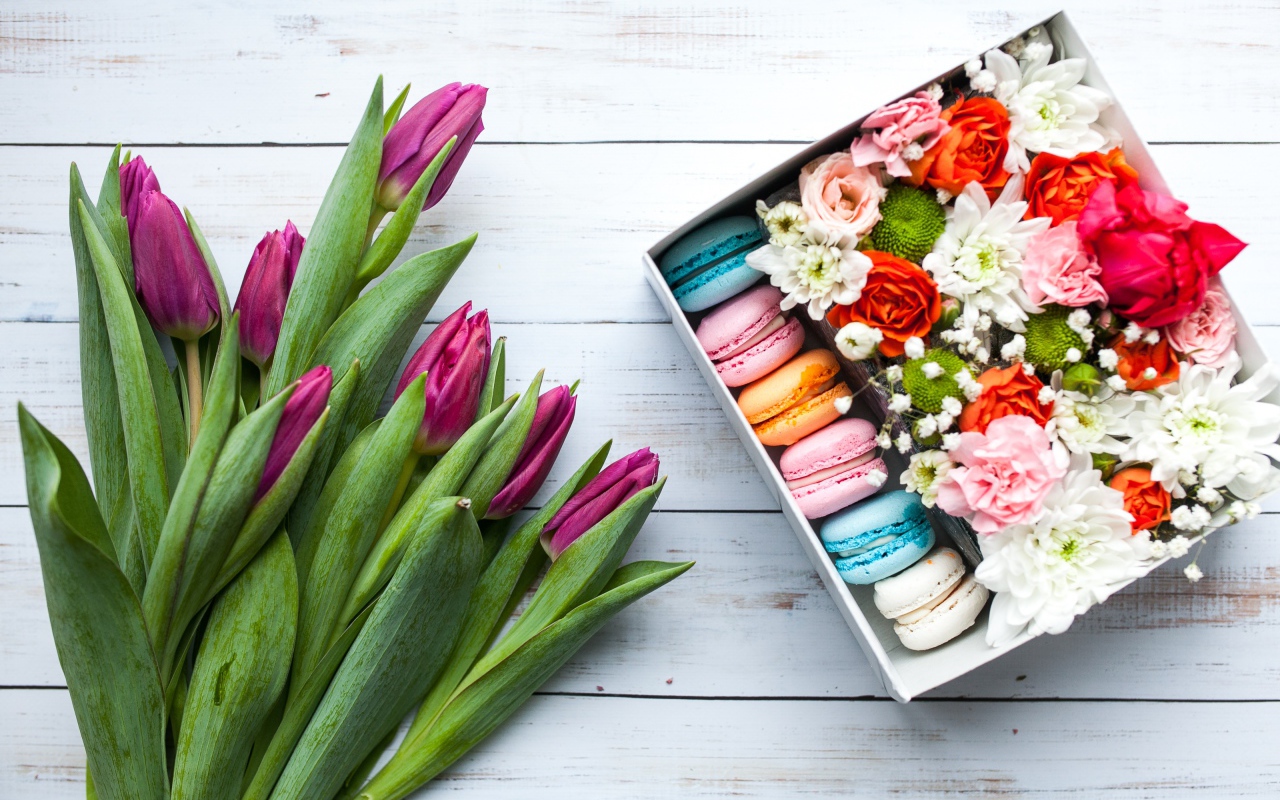 Букет сиреневых тюльпанов на столе с коробкой с макарунами