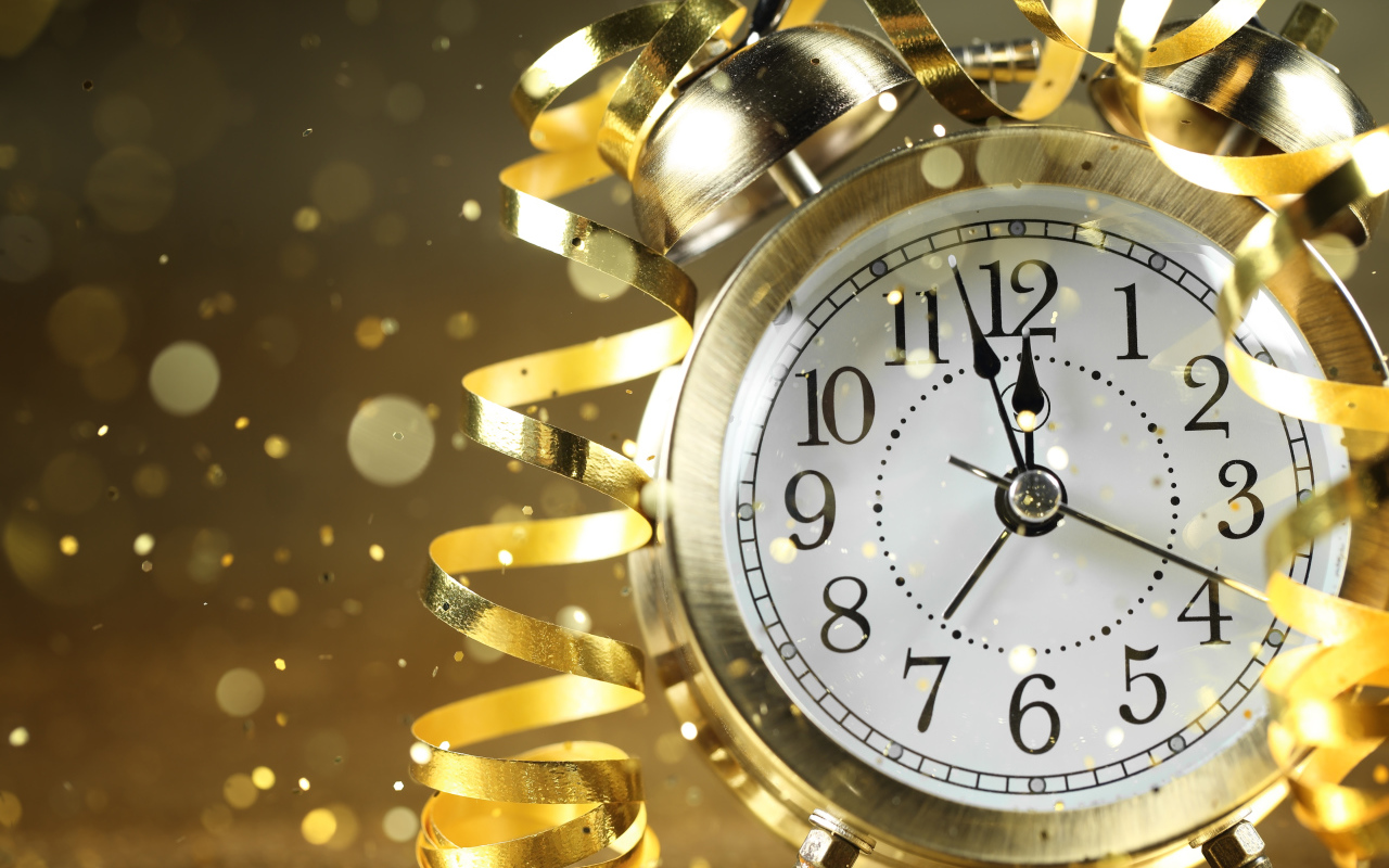 Стрелки новогоднего будильника с серпантином доходят до двенадцати ночи