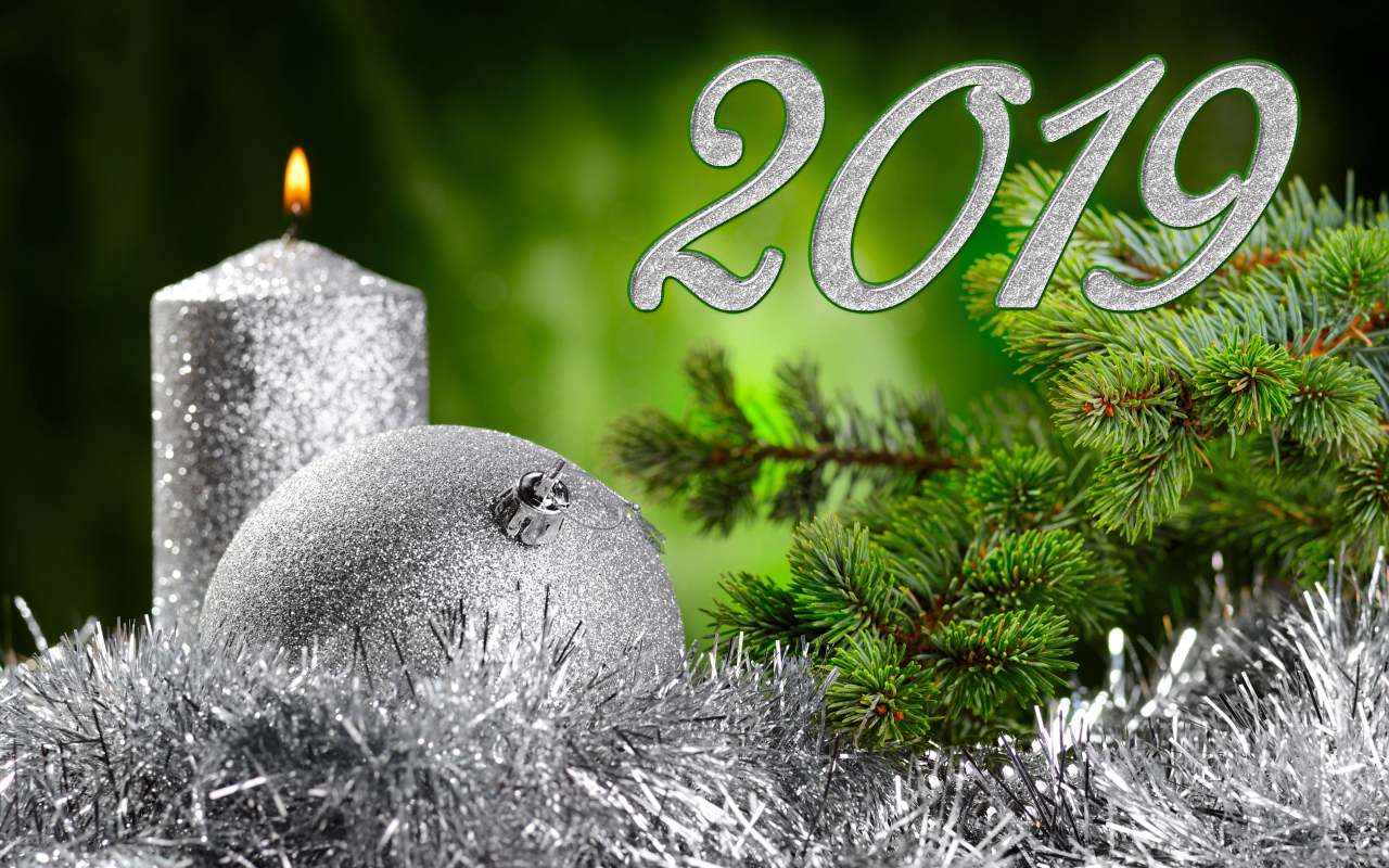 Красивый серебряный шар и свеча с еловой веткой на Новый год и Рождество 2019 