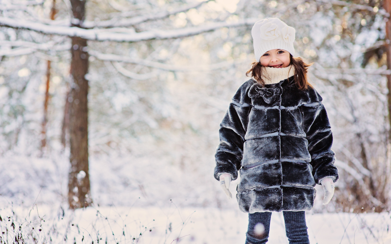 Милая маленькая девочка в шубе зимой