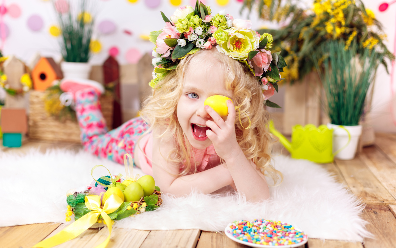 Маленькая веселая девочка с пасхальными яйцами