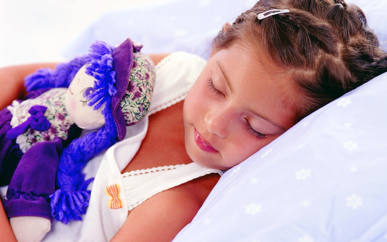 Маленькая девочка спит с игрушкой