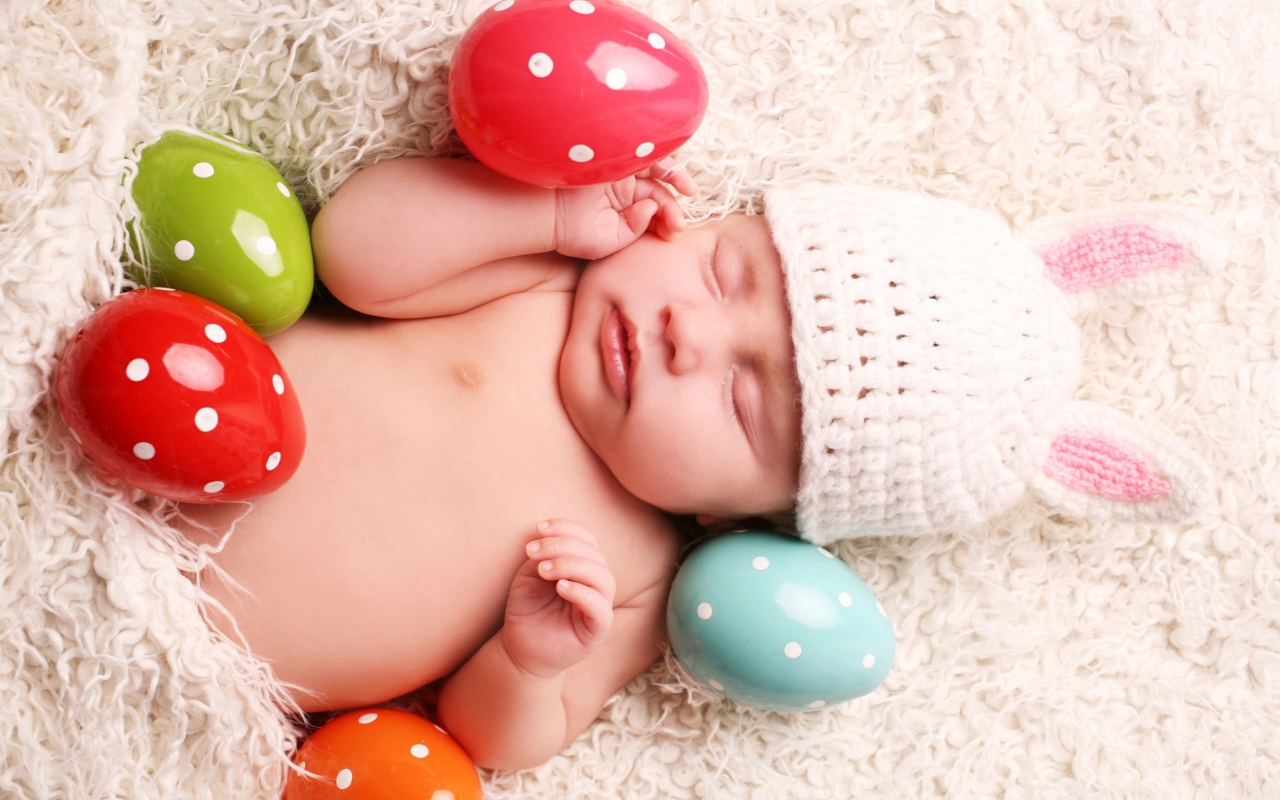 Маленький спящий ребенок с пасхальными яйцами