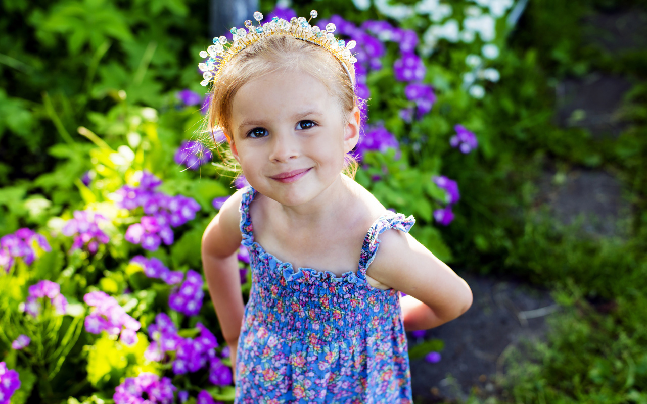 Маленькая улыбающаяся девочка с украшением в волосах 