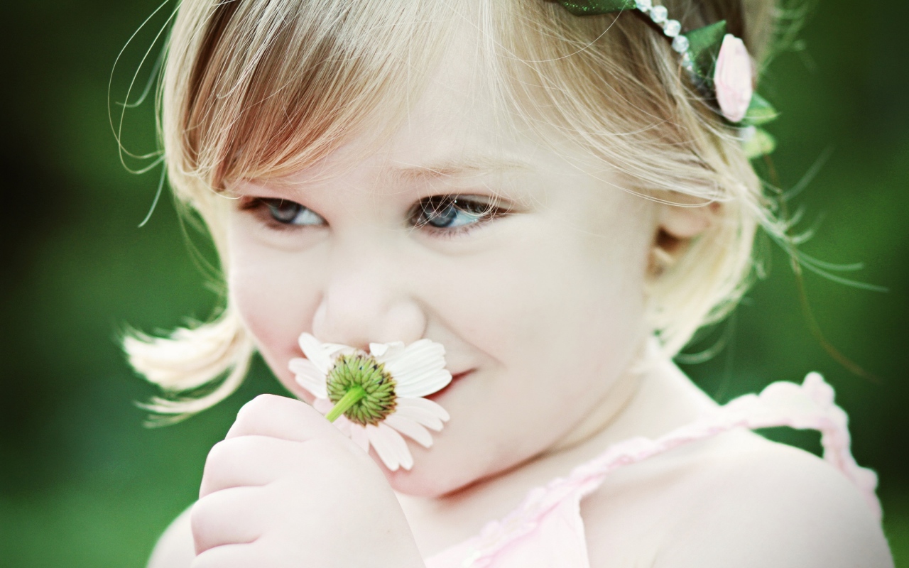 Милая девочка с красивыми глазами с ромашкой