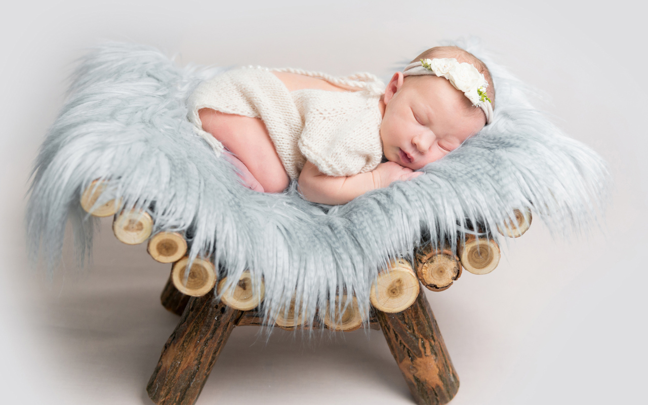 Грудной спящий ребенок лежит на деревянной кроватке