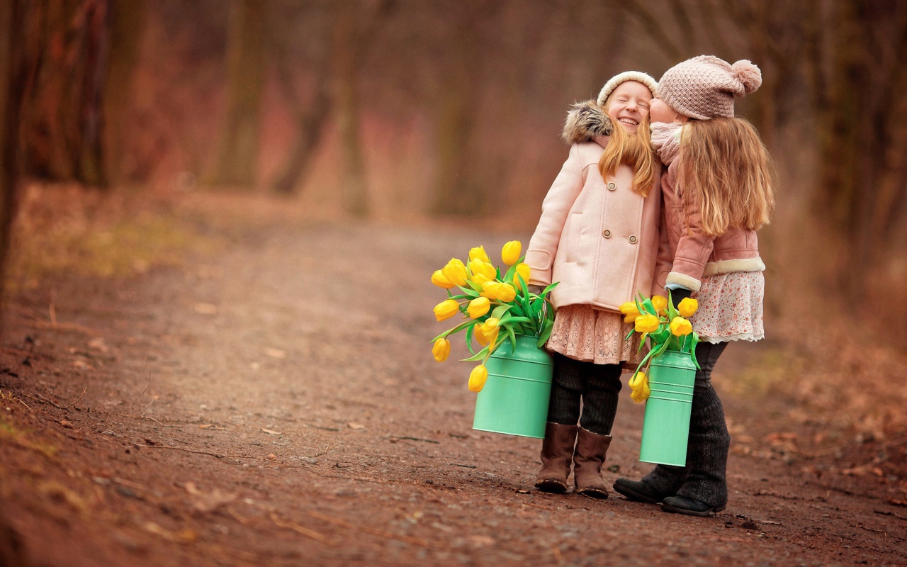 Две маленькие девочки с желтыми тюльпанами весной