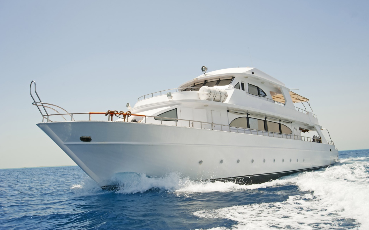 Красивая белая яхта в море на фоне голубого неба 