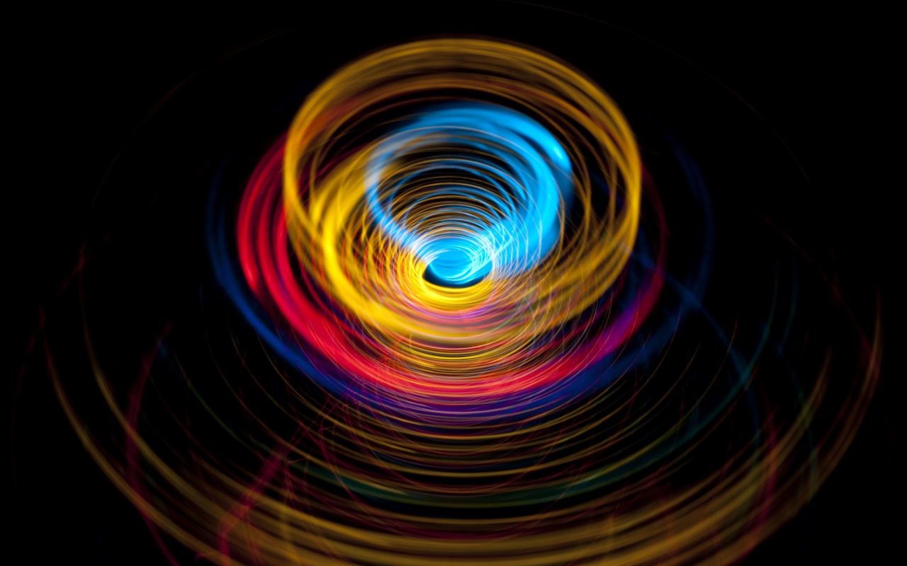 Разноцветные круги в воронке на черном фоне