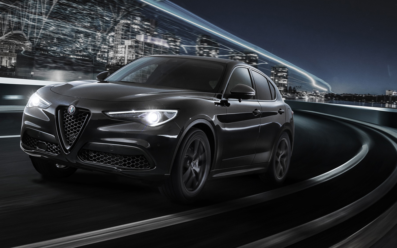 Черный автомобиль Alfa Romeo Stelvio, 2019 года на трассе