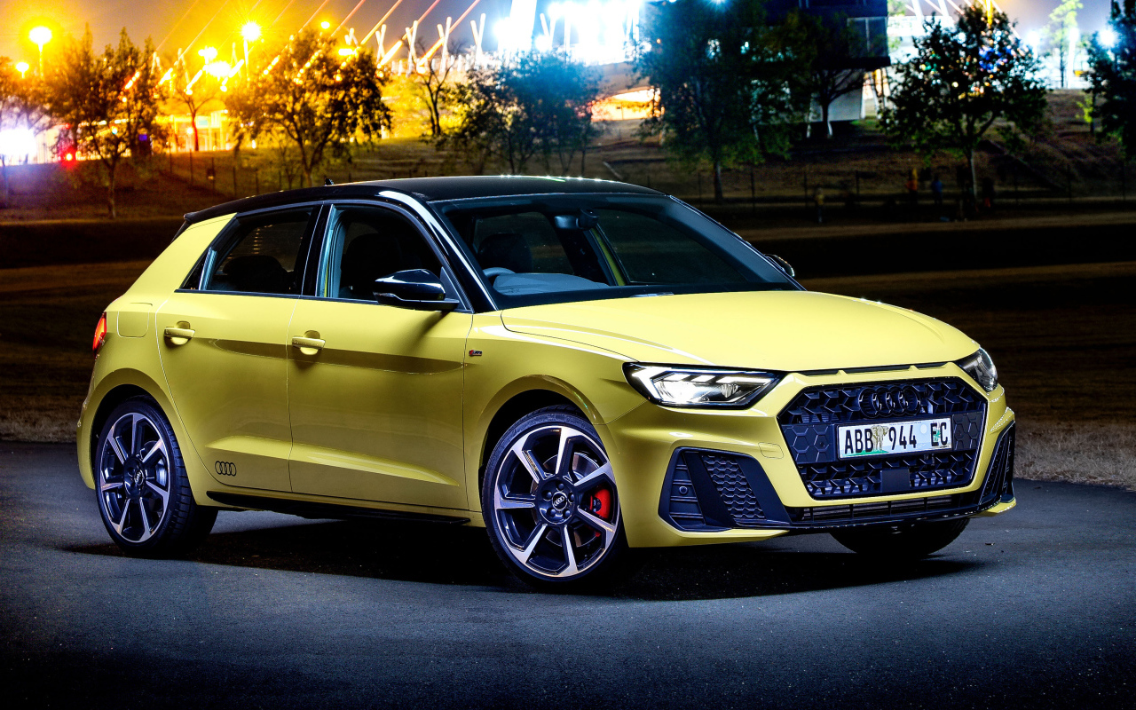 Желтый автомобиль Audi A1 Sportback 40 TFSI S Line Edition One 2019 года на фоне ночного города