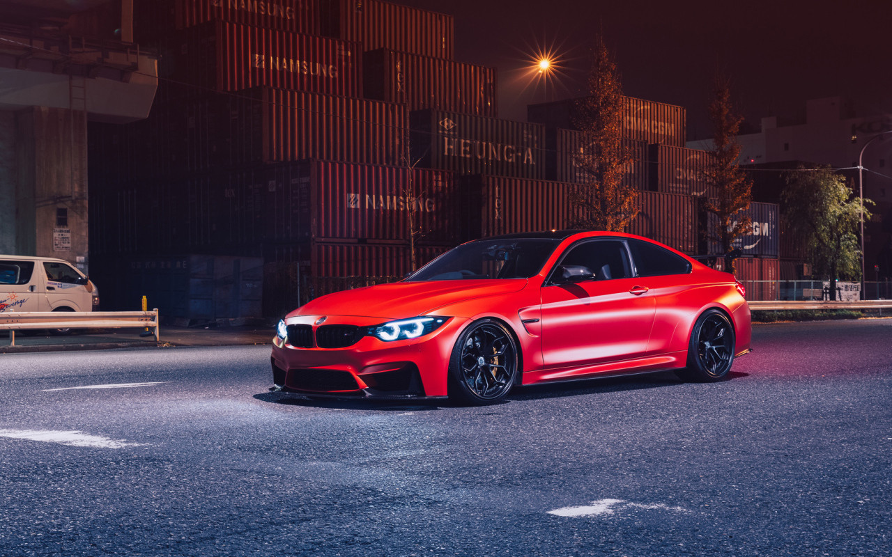 Красный автомобиль BMW M4 на фоне контейнеров