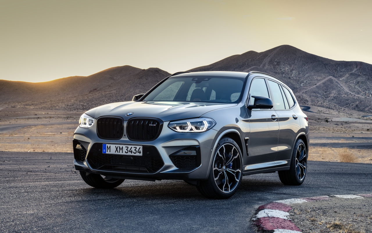 Серебристый автомобиль BMW X3  на асфальте