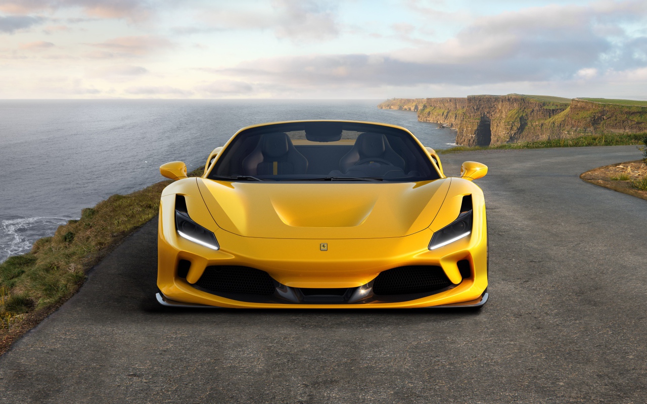 Желтый быстрый автомобиль Ferrari F8 Spider 2019 года у моря