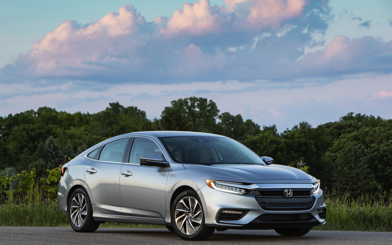 Серебристый автомобиль Honda Insight на фоне леса