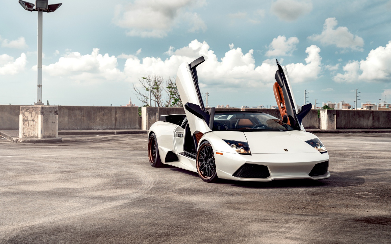 Белый автомобиль Lamborghini Murcielago с открытыми дверями
