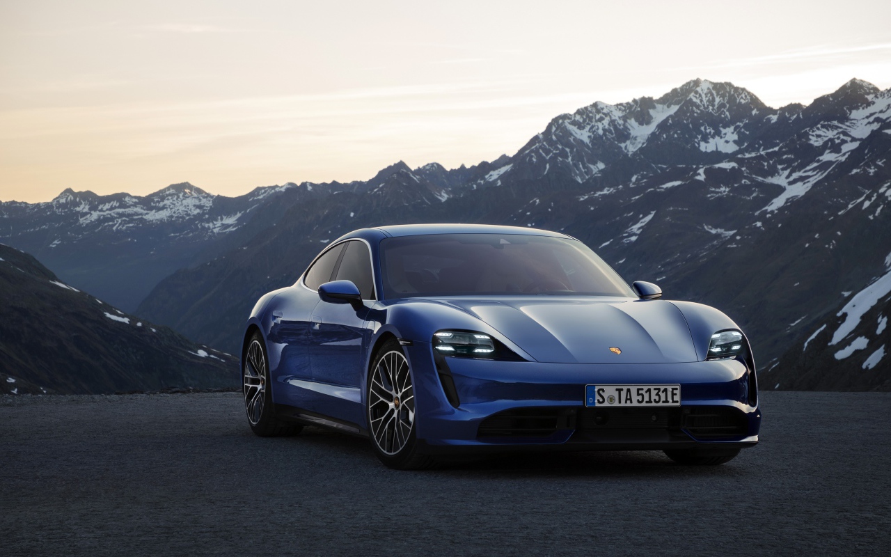 2019 stylish blue car Porsche Taycan Turbo on a background of mountains
