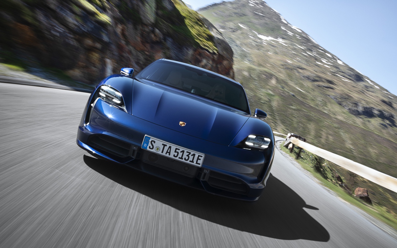 Синий автомобиль Porsche Taycan Turbo 2019 года на фоне гор
