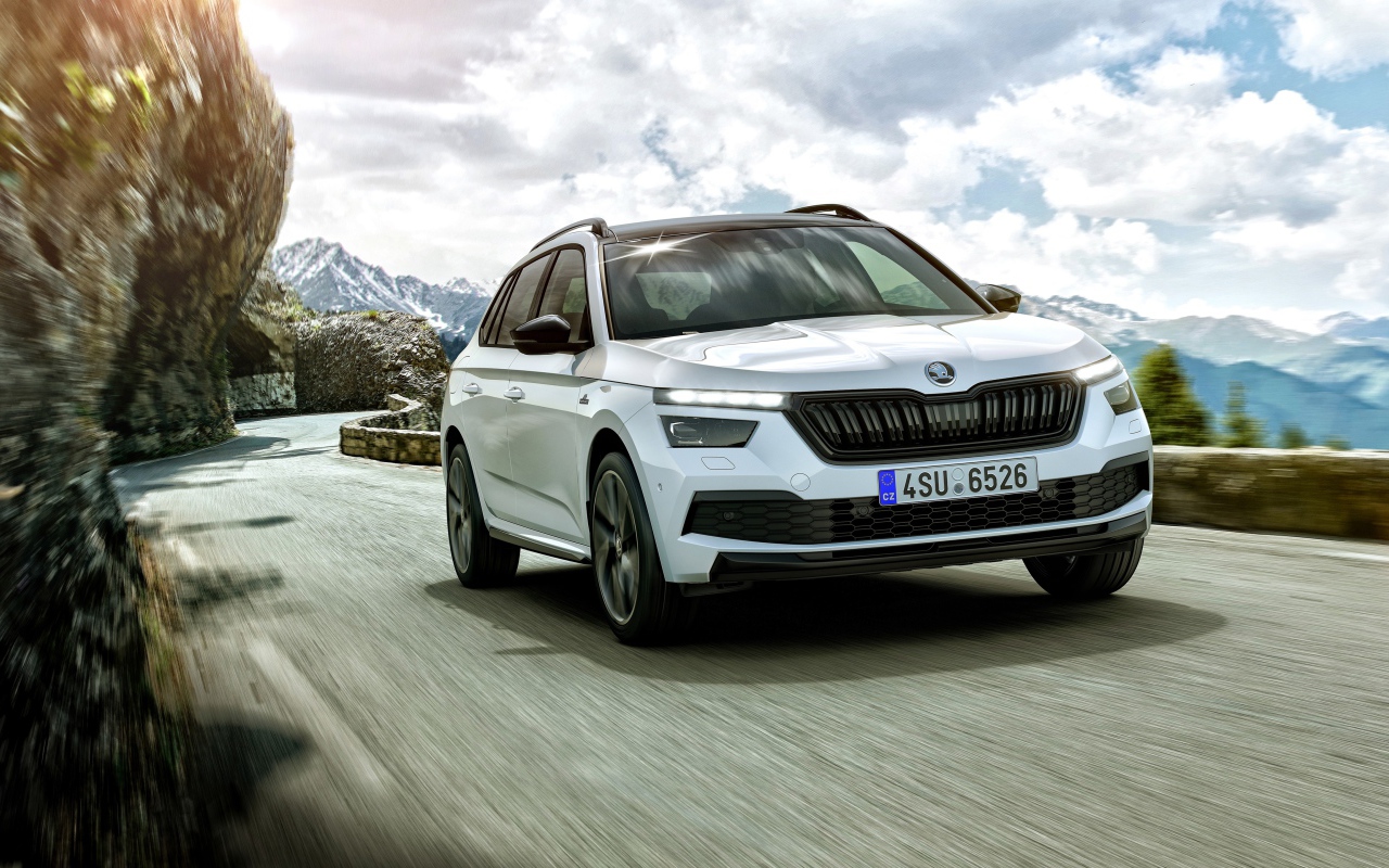 Белый внедорожник Skoda Kamiq Monte Carlo 2019 года на фоне неба в горах