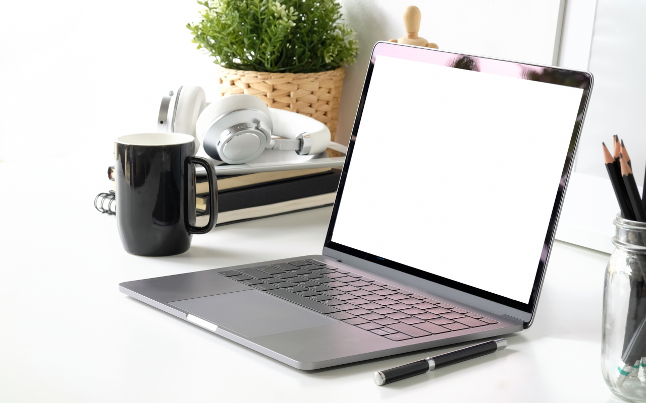 Ноутбук на рабочем столе с чашкой 