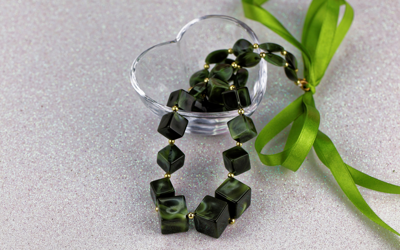 Ювелирное изделие с  бантиком в стеклянной вазочке на столе