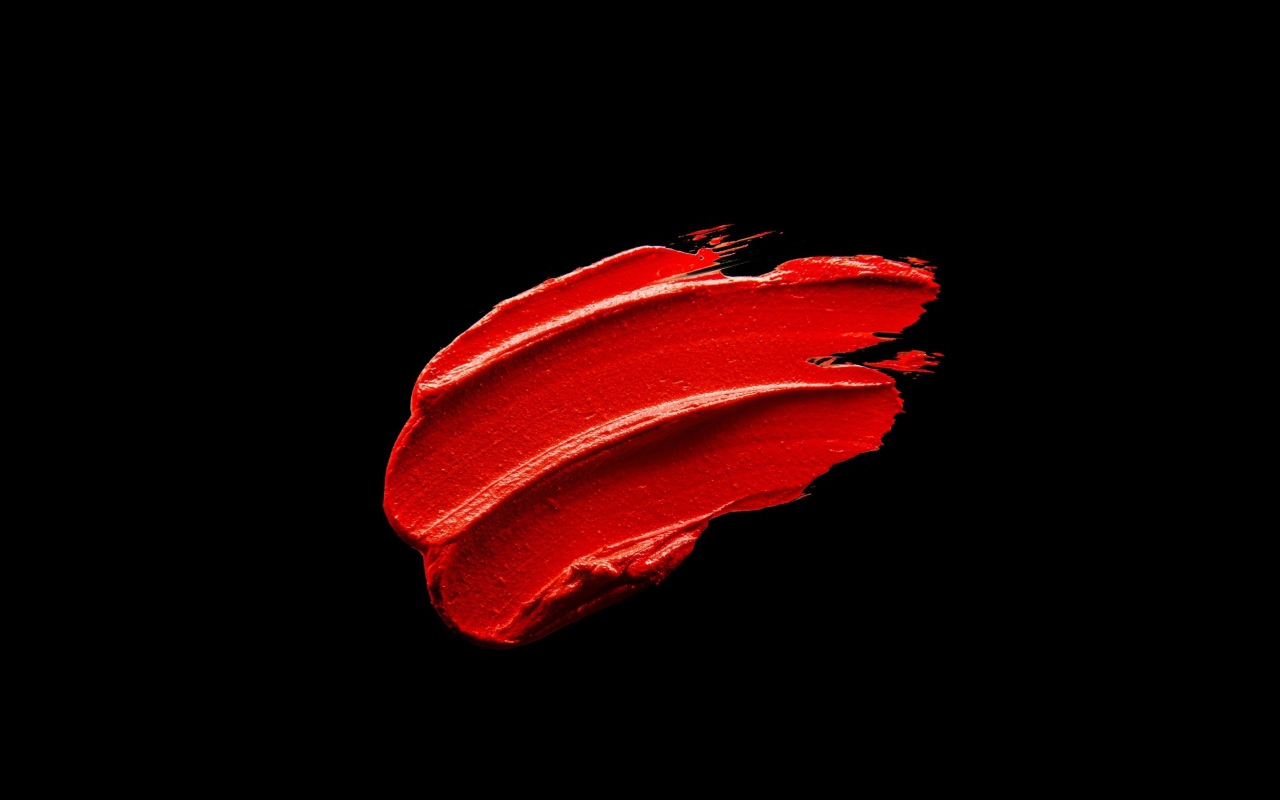 Мазок красной краски на черном фоне