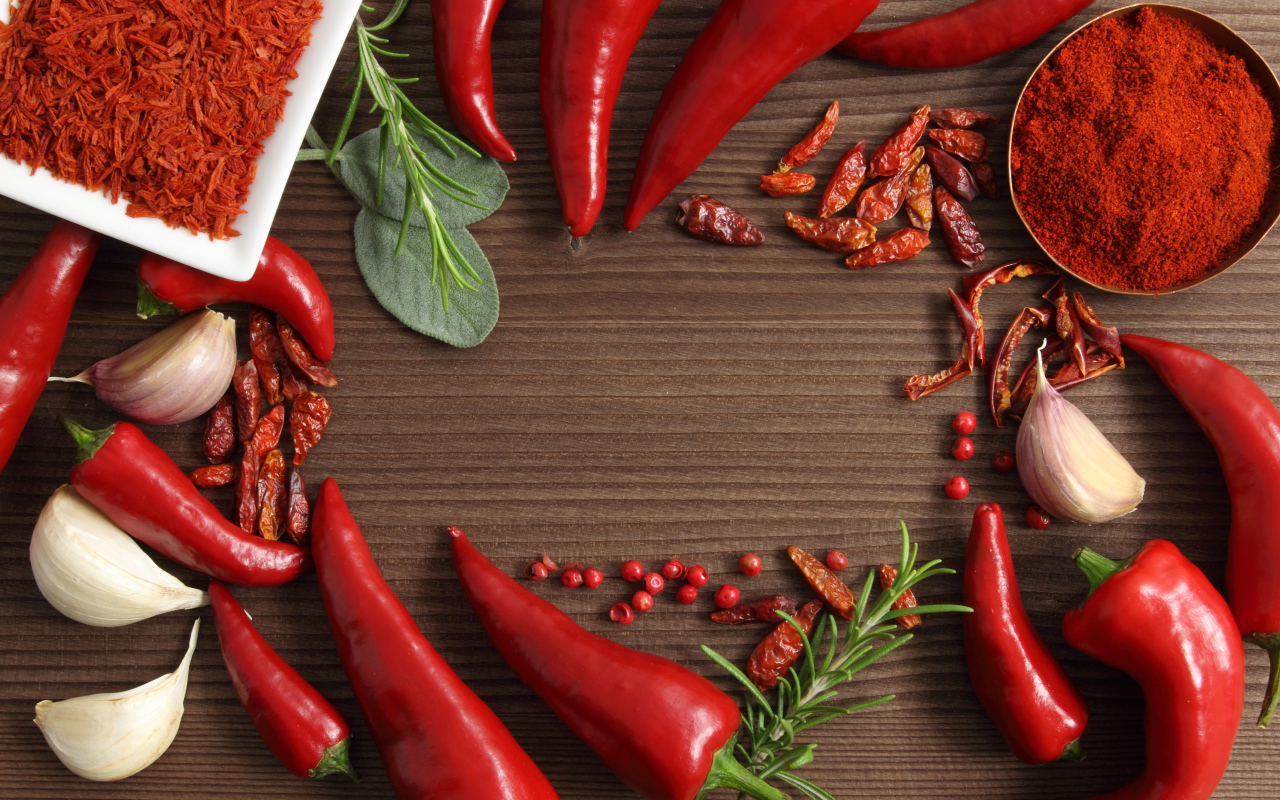 Красный перец с чесноком на деревянном столе