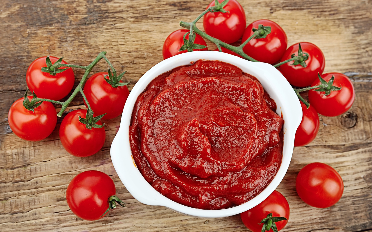 Красные спелые помидоры на столе с кетчупом