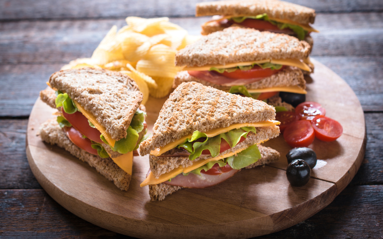 Сэндвичи на деревянной доске с оливками