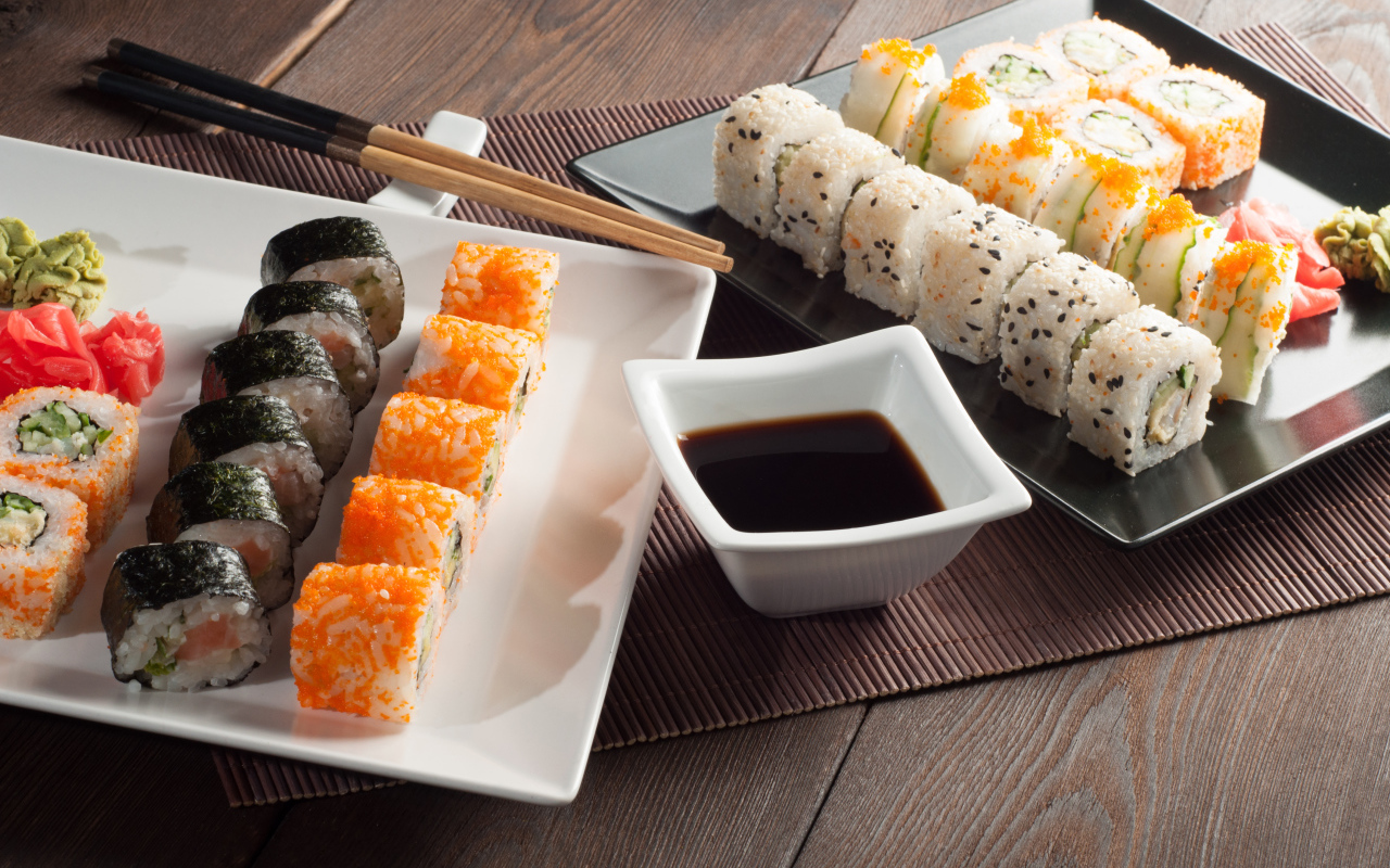 Суши на столе с соевым соусом и палочками