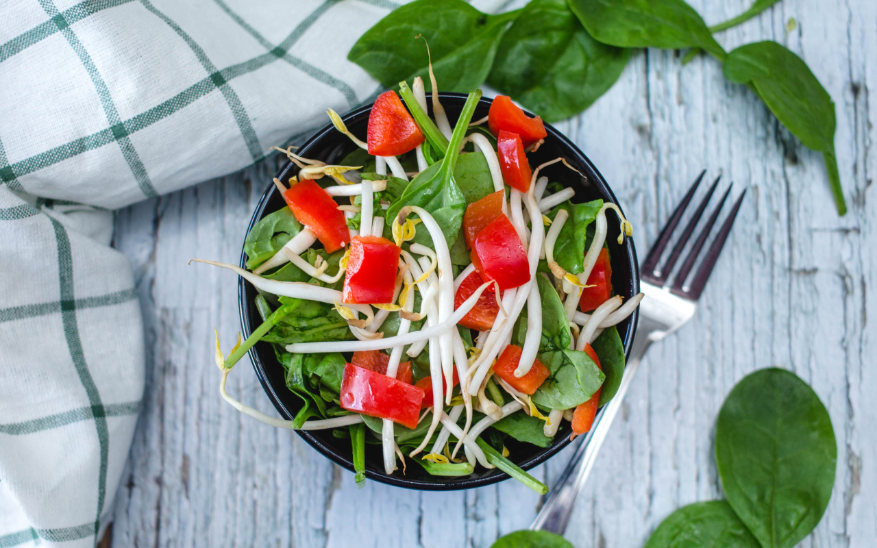 Овощной салат в миске на столе с вилкой