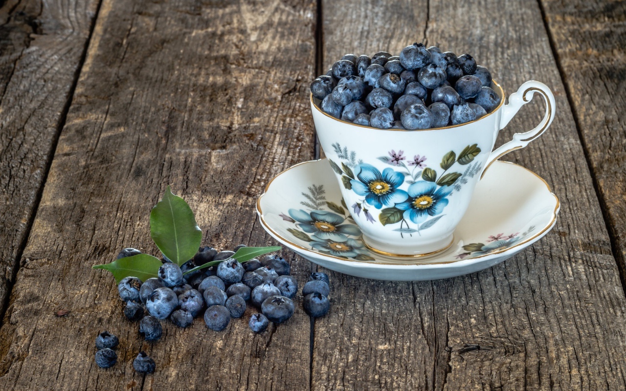 Красивая чашка наполнена ягодами черники