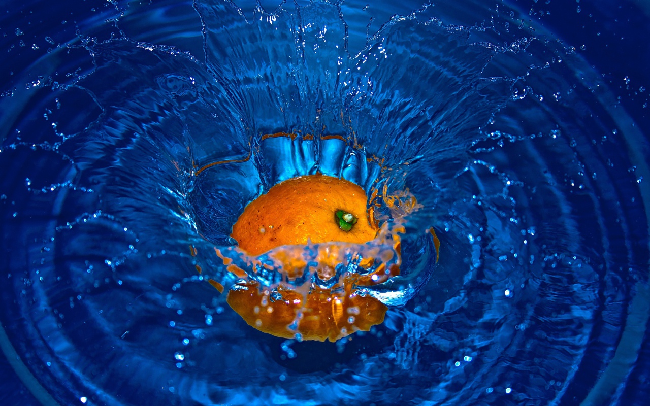 Оранжевый апельсин упал в воду 