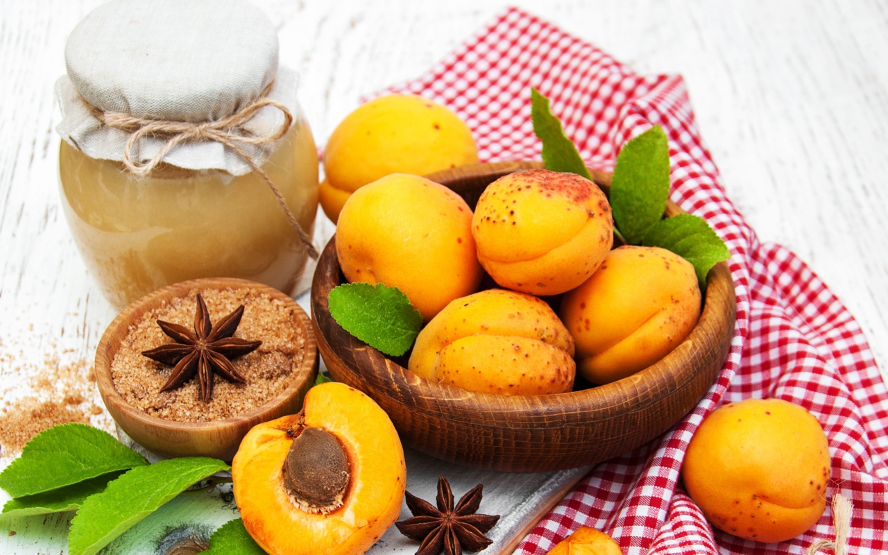 Спелые абрикосы на столе с бадьяном, коричневым сахаром и джемом