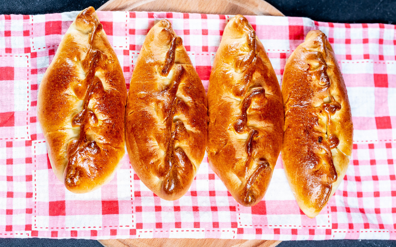 Аппетитные румяные пирожки лежат на полотенце 