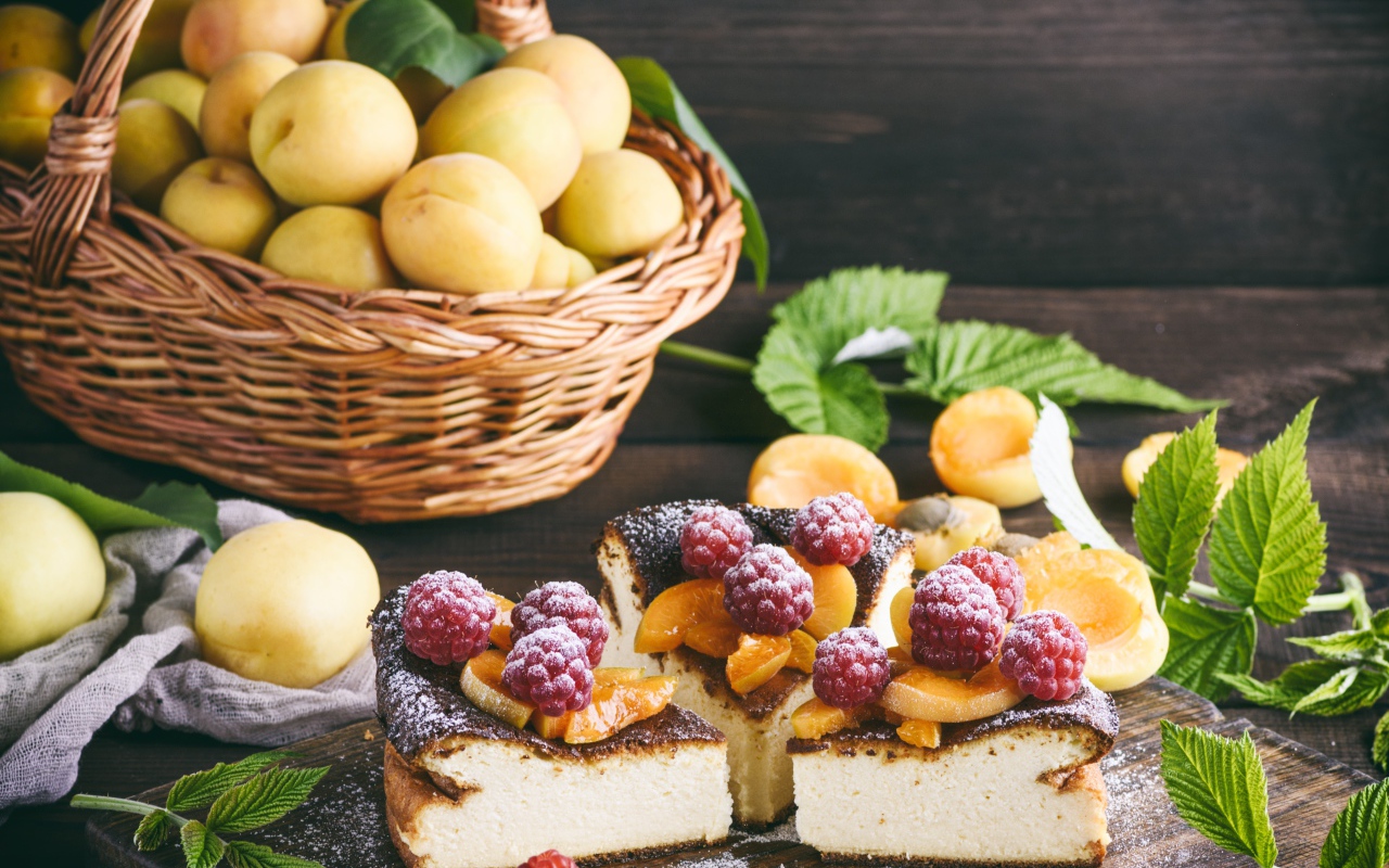 Вкусный фруктово - ягодный пирог на столе с корзиной с абрикосами