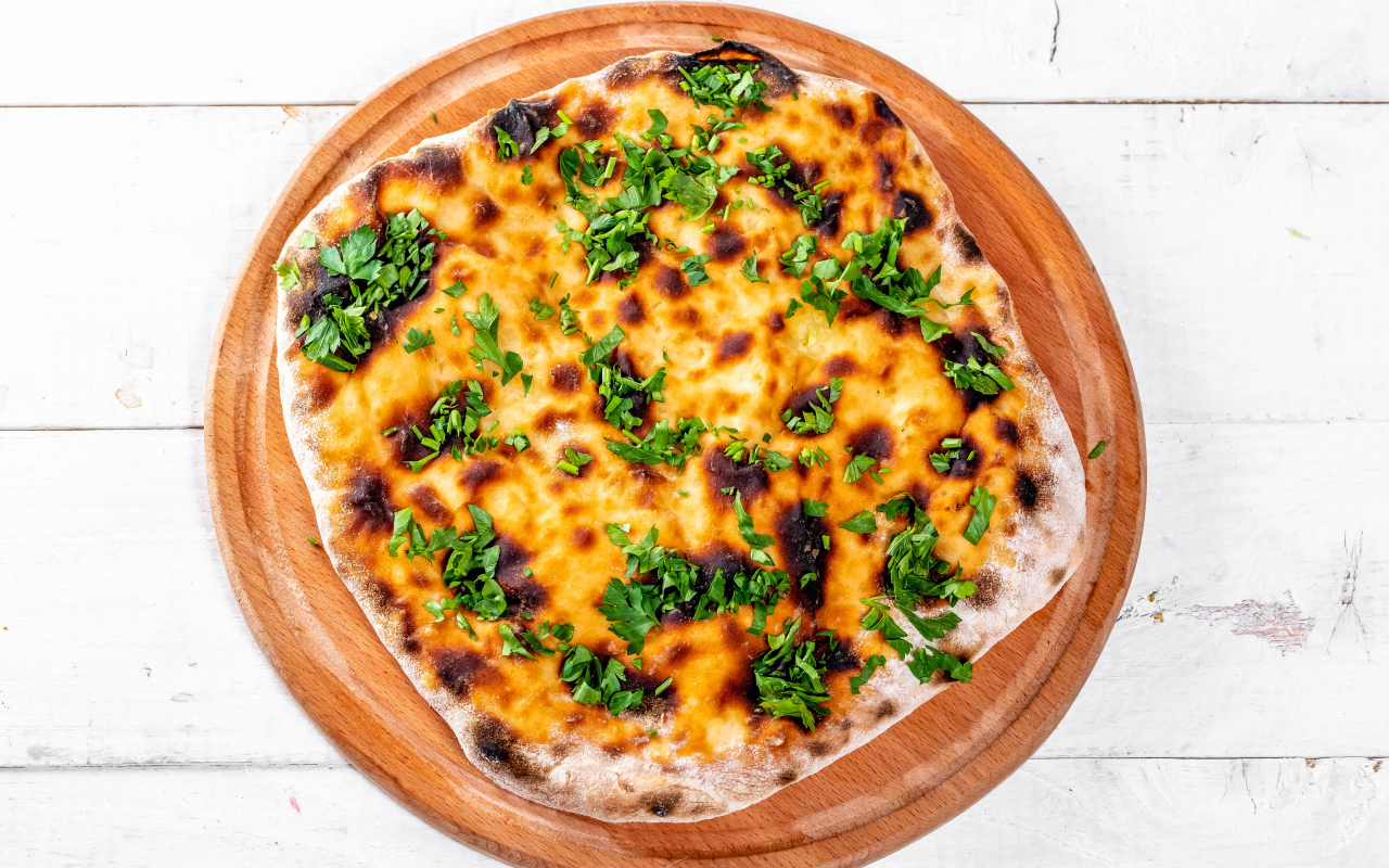 Пирог с сыром и зеленью на доске 