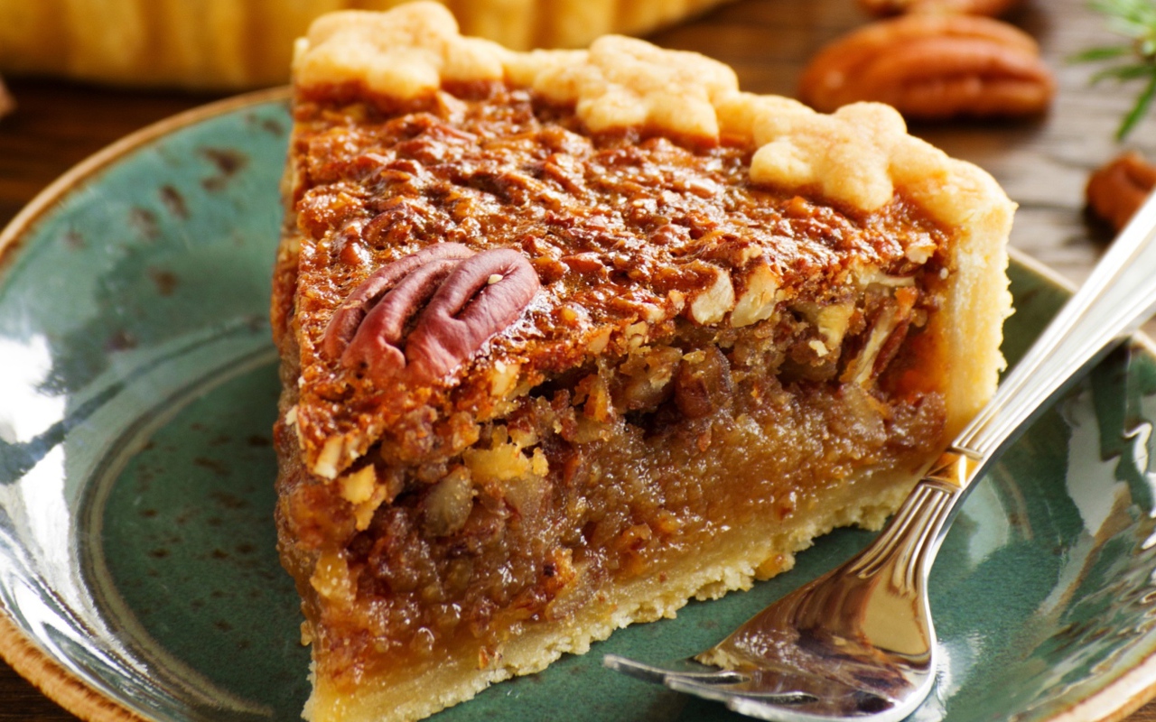 Кусок пирога с орехами на тарелке с вилкой