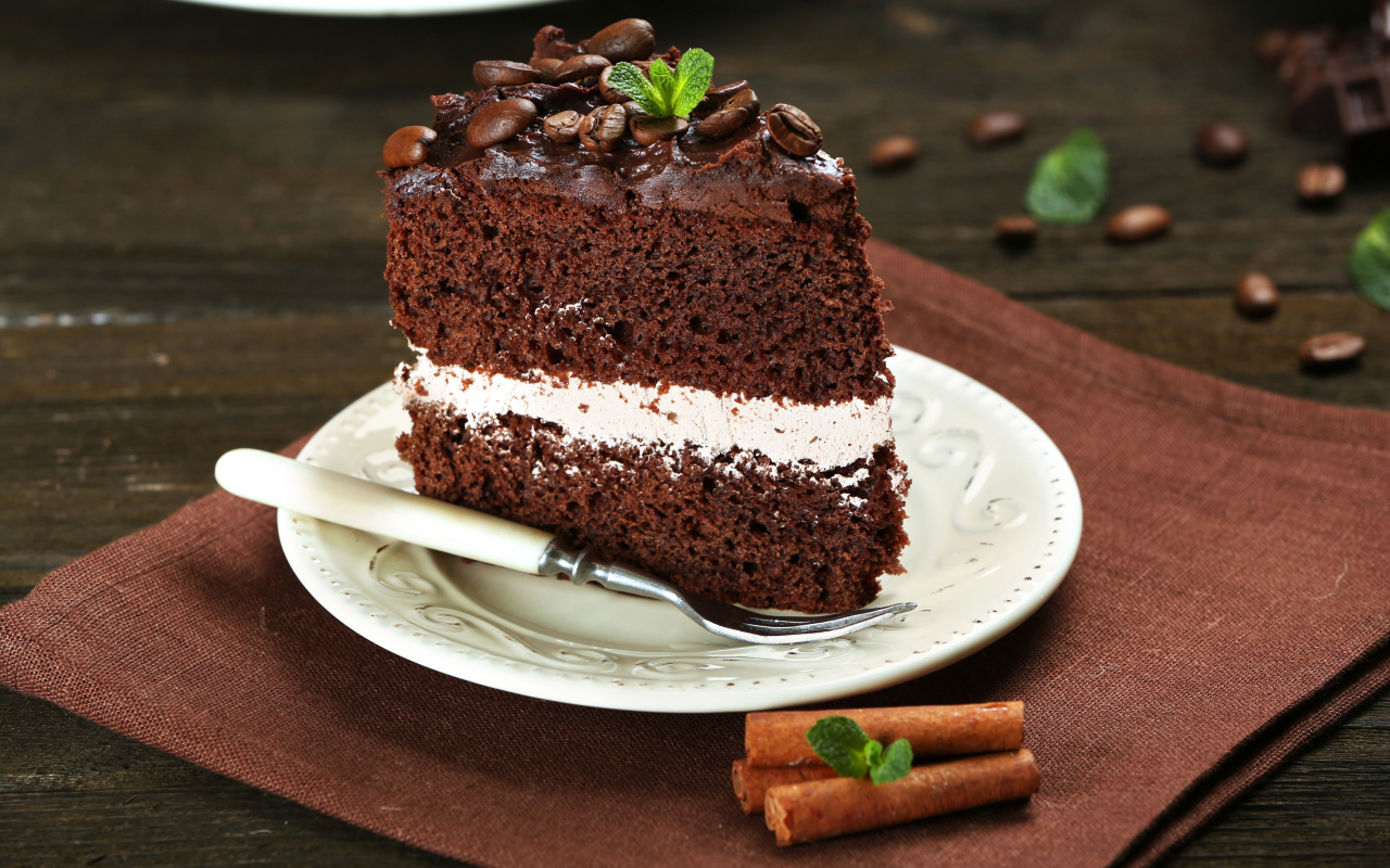 Кусок шоколадного торта с кремом и зернами кофе