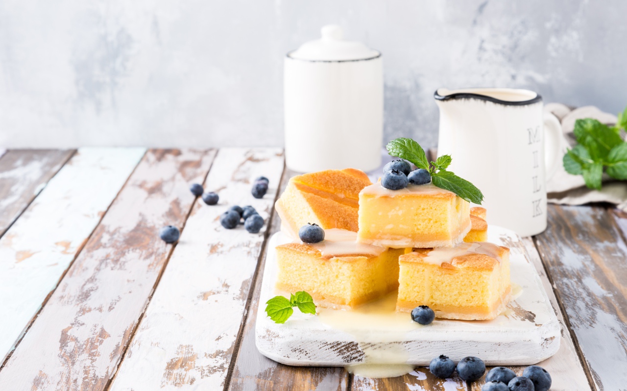 Кусочки бисквитного пирожного на столе с ягодами черники