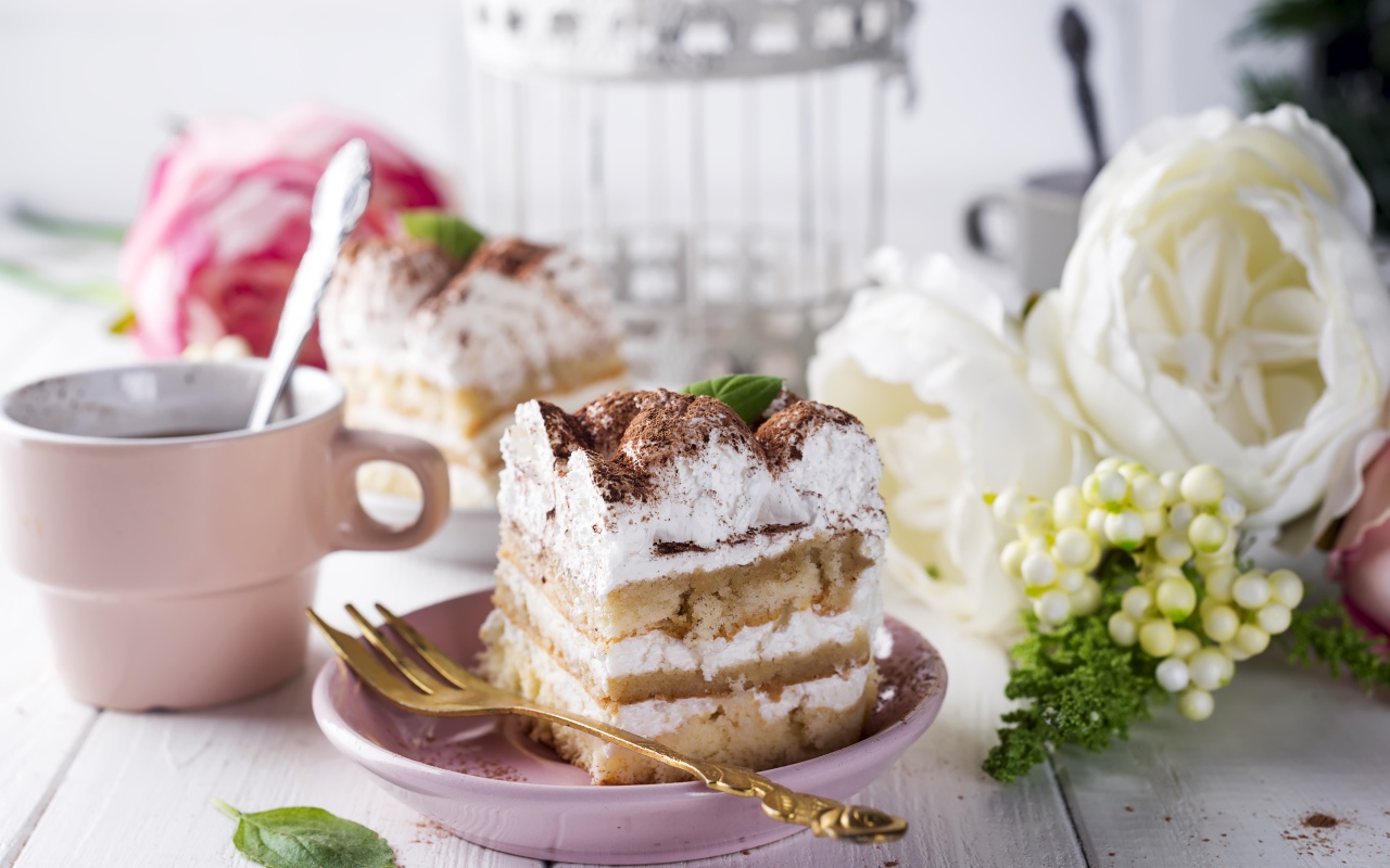 Пирожное на столе с кофе и цветами 