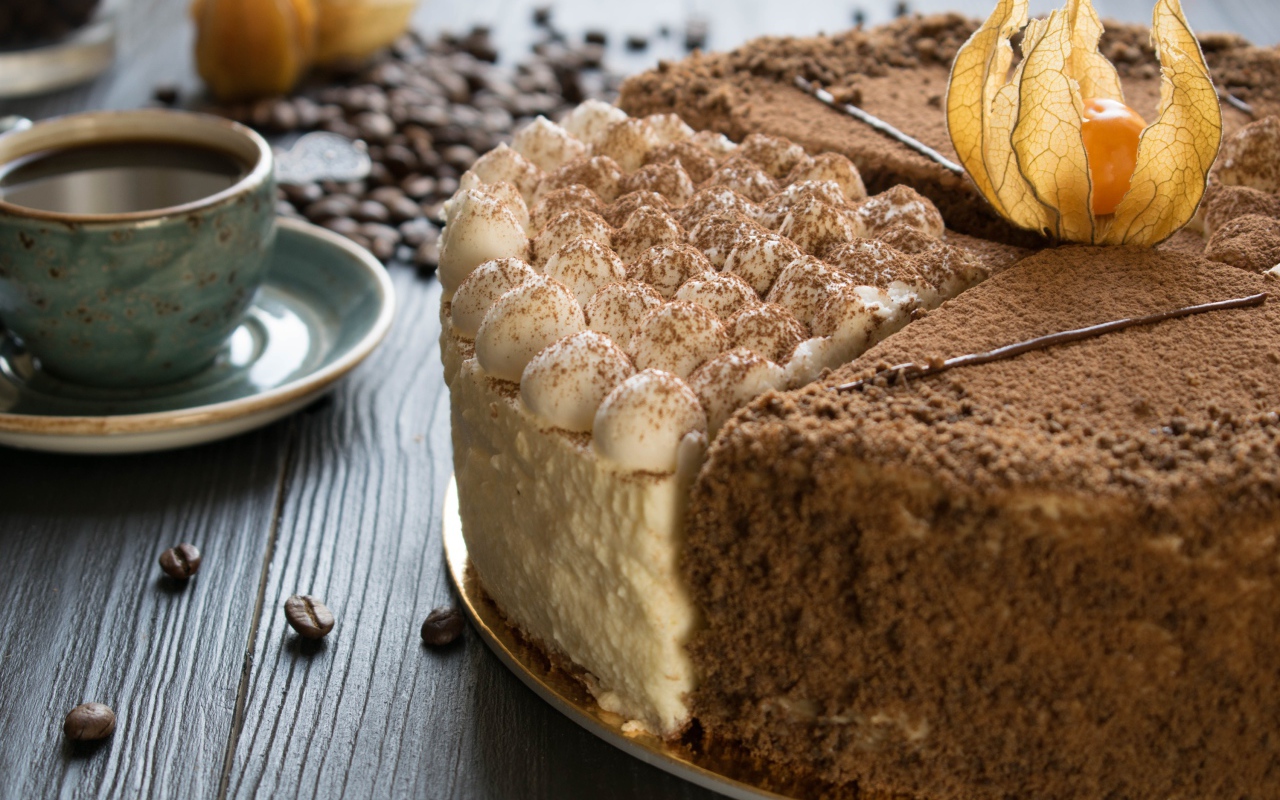 Вкусный торт с кремом и физалисом на столе с кофе