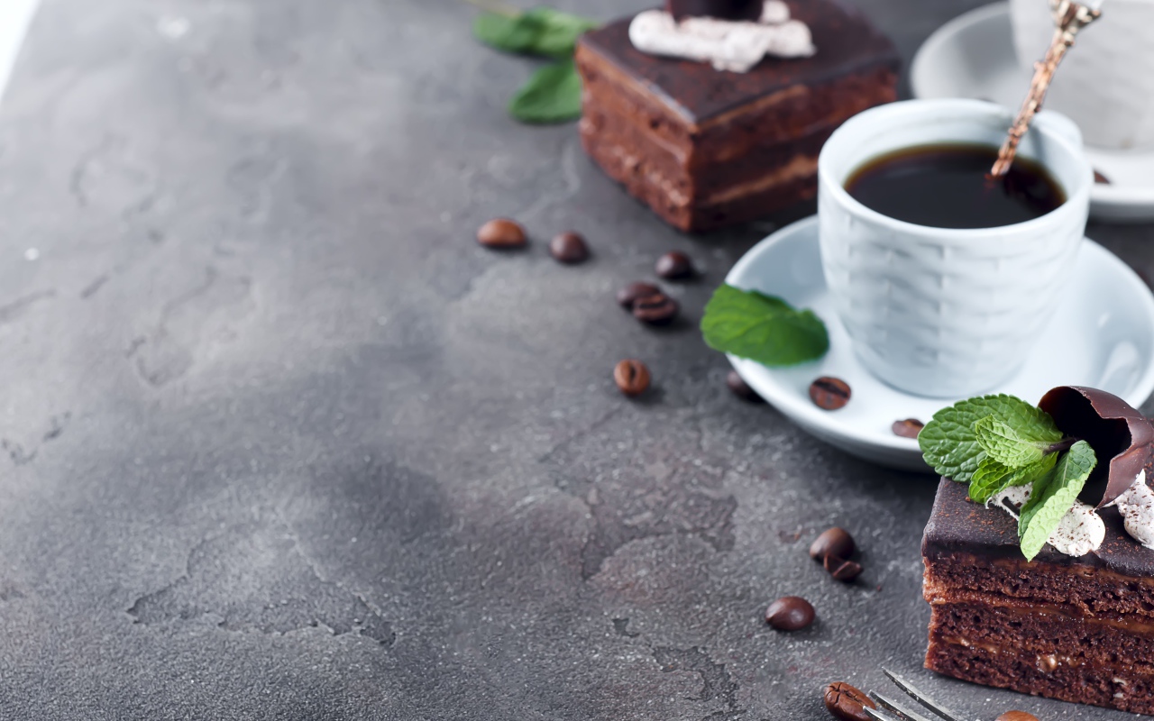 Аппетитное шоколадное пирожное на сером столе с чашкой кофе